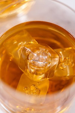 Buzlu viski, viski bardağında, beyaz mermer yüzeyde..