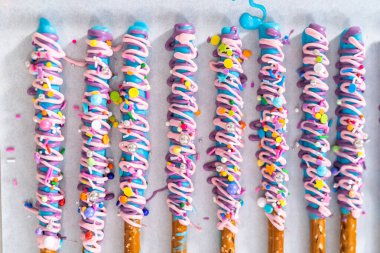 Mermaid chocolate pretzel rods drizzled with pink and purple chocolate and covered with sprinkles. clipart