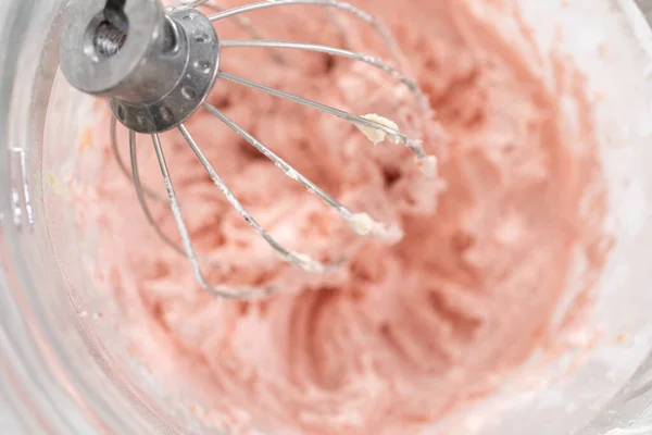 stock image Whipping strawberry buttercream frosting in a stand-alone electric mixer with a whisk attachment.