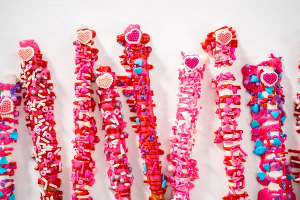 情人节期间 装饰有心形洒水的巧克力覆盖的椒盐卷饼棒 — 图库照片