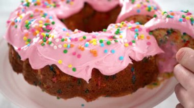 Pembe tereyağlı pasta dilimlenmiş funfettti demetinde pasta ve içi tereyağlı krema dolu..
