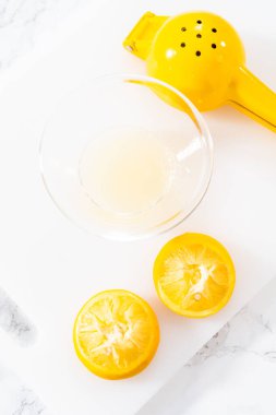 Beyaz bir kesme tahtasının üzerinde taze limon zıp zıp..