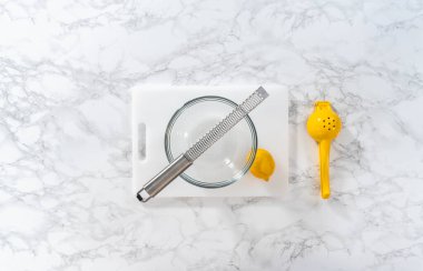 Beyaz bir kesme tahtasının üzerinde taze limon zıp zıp..