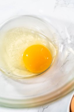 Küçük Paskalya ekmeği pişirmek için ıslak malzemeleri büyük bir bardakta karıştırıyorum..