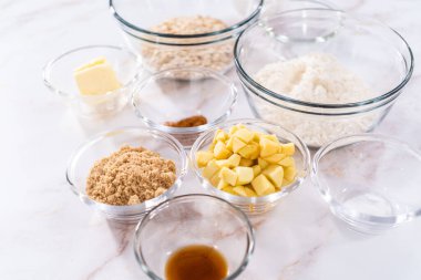 Elmalı yulaflı kurabiye pişirmek için bardaktaki ölçülü malzemeler..