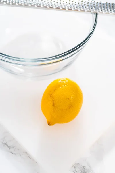 白いまな板の上で新鮮なレモンの皮をむいてジュースを作る — ストック写真