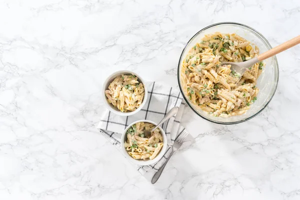 Flat lay. Serving macaroni salad with chicken in white ceramic bowls.