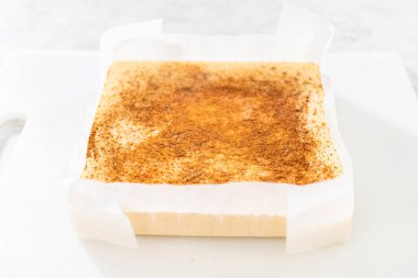 Flat lay. Homemade eggnog fudge pieces on a white cutting board.