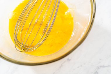 Limonlu yaban mersinli kek pişirmek için büyük bir bardakta ıslak malzemeler karıştırıyorum..