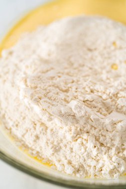 Limonlu yaban mersinli kek yapmak için büyük bir bardakta karıştırma malzemesi..