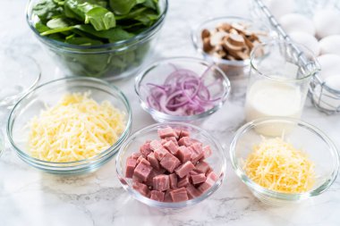 Ispanak ve jambonlu frittata hazırlamak için cam karıştırma kabındaki malzemeler..