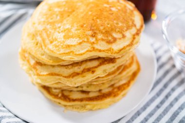 Dilimlenmiş muz, kızarmış hindistan cevizi ve akçaağaç şurubuyla süslenmiş taze hindistan cevizli krep yığını..