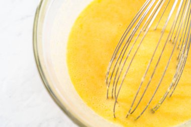 Limonlu yaban mersinli kek pişirmek için büyük bir bardakta ıslak malzemeler karıştırıyorum..