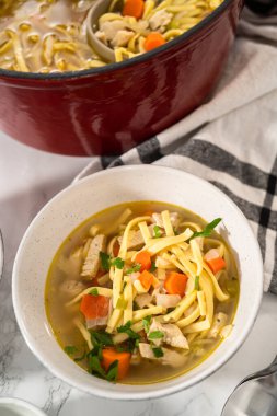 Beyaz seramik çorba kaselerinde kluski şehriyeli tavuk çorbası servis ediyorum..