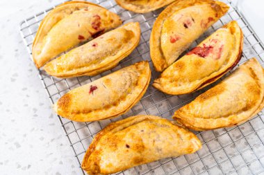 Mutfak tezgahındaki tavada taze pişmiş vişneli börek var..