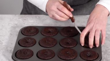 Tereyağlı kremayla süslemek için taze pişmiş çikolatalı kekler..