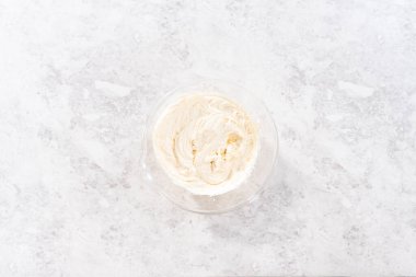 Flat lay. Preparing store-bought buttercream frosting to make unicorn rainbow chocolate cupcakes.