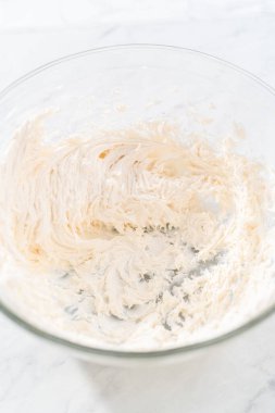 Zencefilli keki karamel ile süslemek için elektrikli el mikseriyle çırpılmış tereyağı kreması..