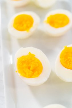 Beyaz servis tabağında dilimlenmiş haşlanmış yumurta..