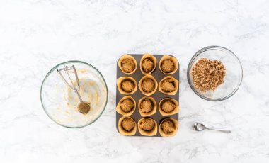 Düz yatıyordu. Muzlu yulaf ezmeli kek pişirmek için Lale kağıtlı kek dilimleriyle kaplanmış kek tepsisine hamur kepçesiyle hamur toplamak..