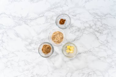 Flat lay. Measured ingredients in glass mixing bowls to bake banana oatmeal muffins.