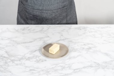 Sıcak bardağın altındaki tuzsuz tereyağı çubuğu.