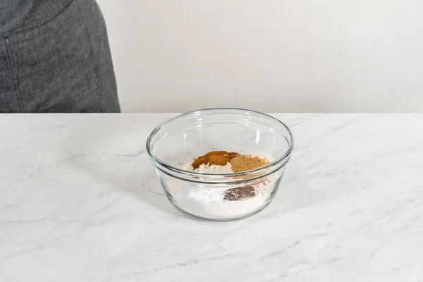 将干配料和手工搅拌在一个大玻璃杯中搅拌 将姜饼包在焦糖中烘烤 — 图库照片