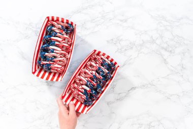 Flat lay. American flag. Red, white, and blue chocolate-covered pretzel twists.