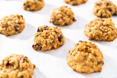 Mutfak tezgahında taze pişmiş yulaf ezmeli kuru üzümlü cevizli kurabiye..