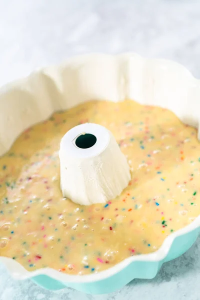 Cake batter in a bundt cake pan to bake funfettti bundt cake.