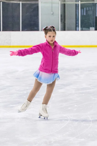 小さな女の子練習フィギュアスケート上の屋内アイスリンク — ストック写真