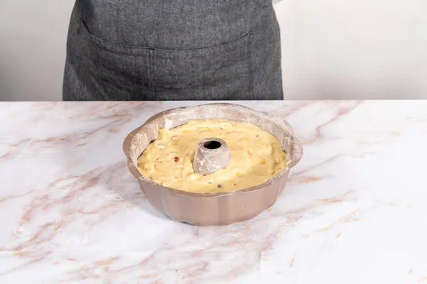 Cake batter in a bundt cake pan to bake apple bundt cake with caramel glaze.