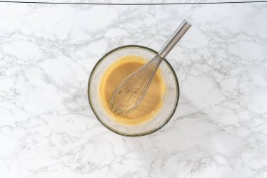 Düz yatıyordu. Limonlu haşhaşlı kek pişirmek için büyük bir bardakta ıslak malzemeler karıştırıyorum..