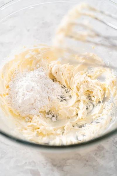大規模な混合ボウルにハンドミキサーで材料を混合し ニンジンバンドケーキのクリームチーズの霜降りを作るために — ストック写真