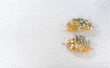 Düz yatıyordu. Ev yapımı donmuş karides paketleri plastik yeniden mühürlenebilir poşetlere hazırlanıyor..