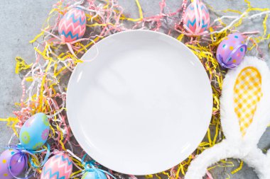 Paskalya temalı masaya boş beyaz tabak.