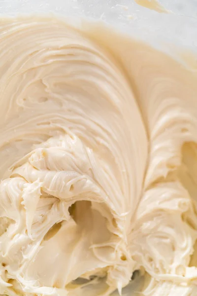 大規模な混合ボウルにハンドミキサーで材料を混合し ニンジンバンドケーキのクリームチーズの霜降りを作るために — ストック写真