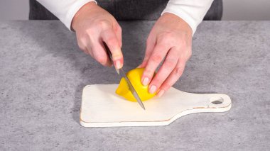 Adım adım. Beyaz tabakta organik limon dilimleri dilimliyorum..