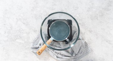 Düz yatıyordu. Çikolata parçacıkları ve diğer malzemeleri kaynayan suyun üzerinde karıştırarak fındıklı çikolatalı şekerleme hazırlıyorum..