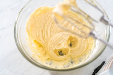 Krem peyniri kek yapmak için büyük bir bardakta karıştırma malzemesi..