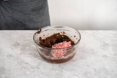 Naneli çikolata parçalarını çikolatalı kurabiye hamuruna katlayıp naneli kurabiye pişirmek..