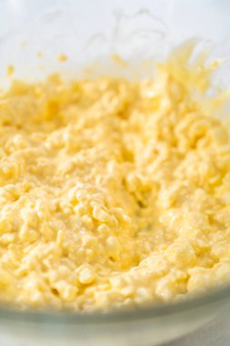 Krem peyniri kek yapmak için büyük bir bardakta karıştırma malzemesi..