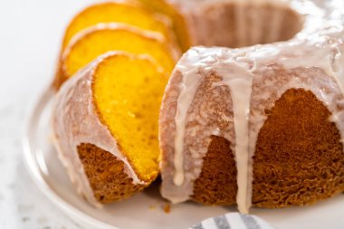 Dilimlenmiş vanilyalı kek, beyaz bir tabakta beyaz jöleli..