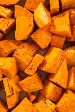 Fırında kızartılmış tatlı patates yapmak için parşömen kağıdıyla kaplı fırında tatlı patatesler..