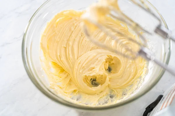 大きなガラス混合ボウルに材料を混合し 束ケーキのためのクリームチーズ充填を作るために — ストック写真