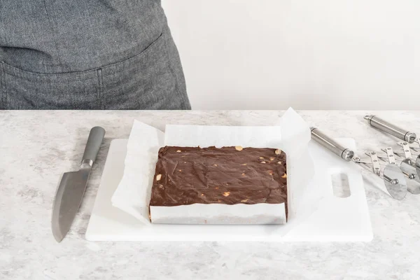 Bort Choklad Makadamiagram Från Fyrkantig Cheesecake Pan Fodrad Med Pergament — Stockfoto