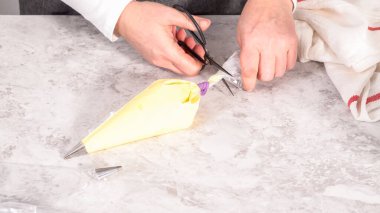 Adım adım. Tek boynuzlu at meringue kurabiyesi pişirmek için metal uçlu boru torbalarına krema karıştırılıyor..