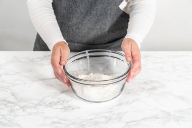 Kuru malzemelerle büyük bir bardakta çırpma kabını karıştırıp mini vanilyalı kekleri ombre pembe tereyağlı kremayla karıştırıyorum..