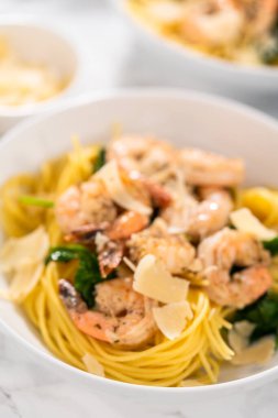 Beyaz seramik kaselerde ıspanaklı sarımsaklı karides makarnası servis ediyorum..