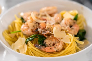 Beyaz seramik kaselerde ıspanaklı sarımsaklı karides makarnası servis ediyorum..